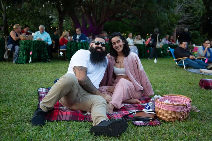 A couple sits on the grass
