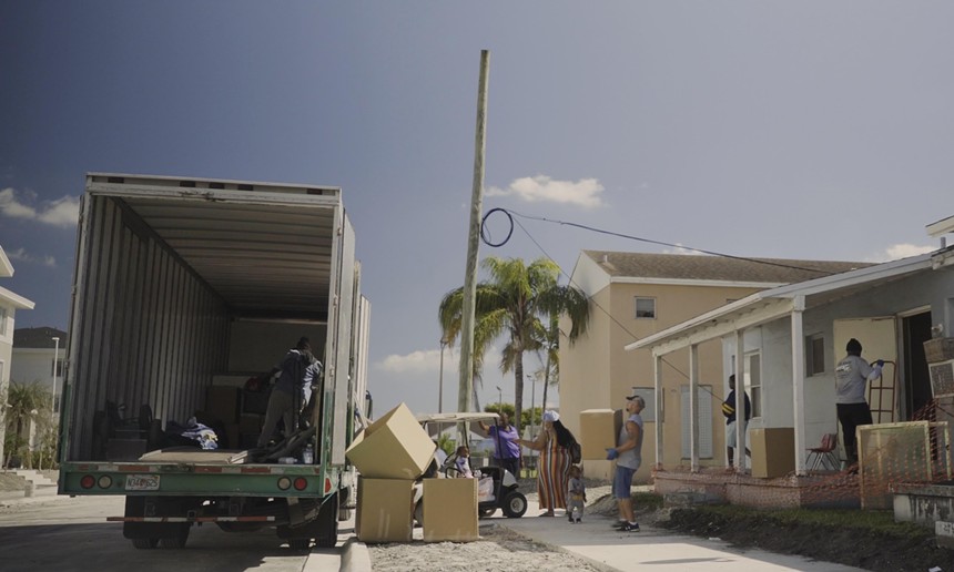 A family loads up their possessions onto a moving truck
