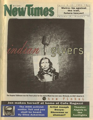 A tabloid newspaper cover showing an old-style stand microphone from which hangs an archival photo of a Native American