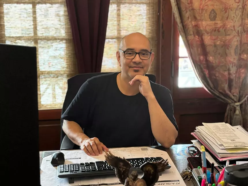 Eriberto Jiménez sitting at his desk while looking at the camera