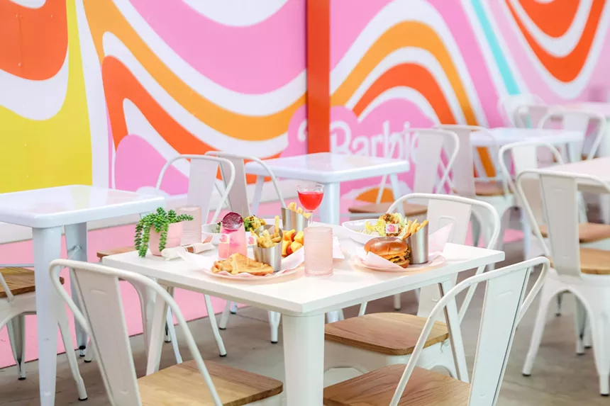 A table with food surrounded by walls with pink swirls