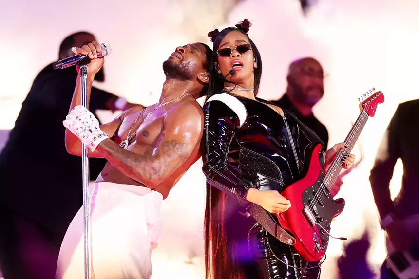 Usher and H.E.R. standing back to back
