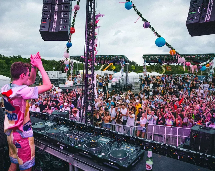A DJ in the booth performing before a crowd