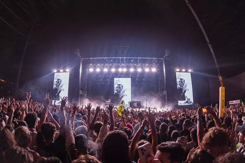 Crowd cheers as Fred Again performs on stage