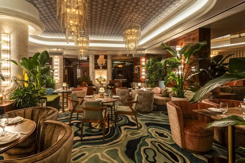 A restaurant dining room with a carpet in tones of green