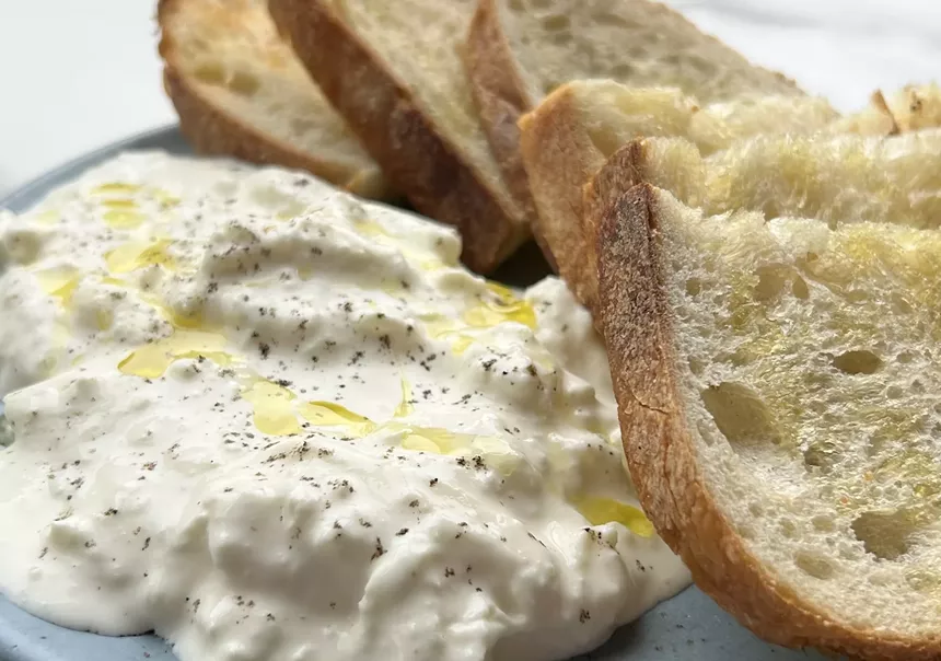 Stracciaitella and housemade sourdough bread on a white plate