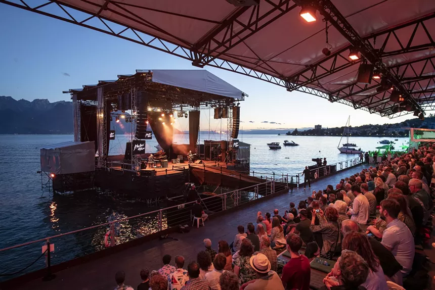 Crowd looking at the performance happening on stage with Lake Geneva in the background