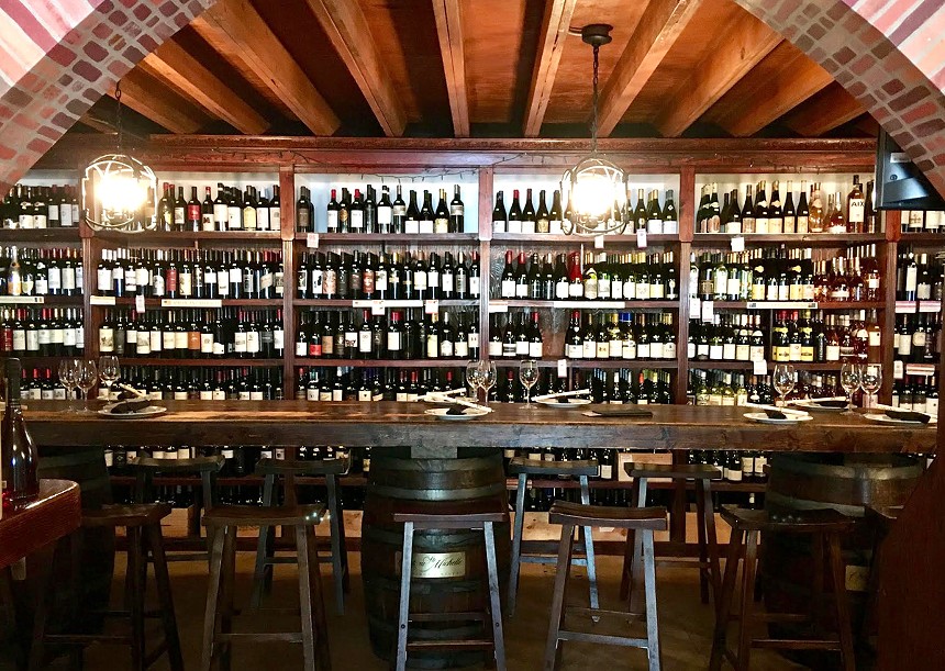 A long dining table and bottles of wine