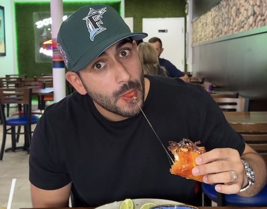 A man in a black shirt eating food