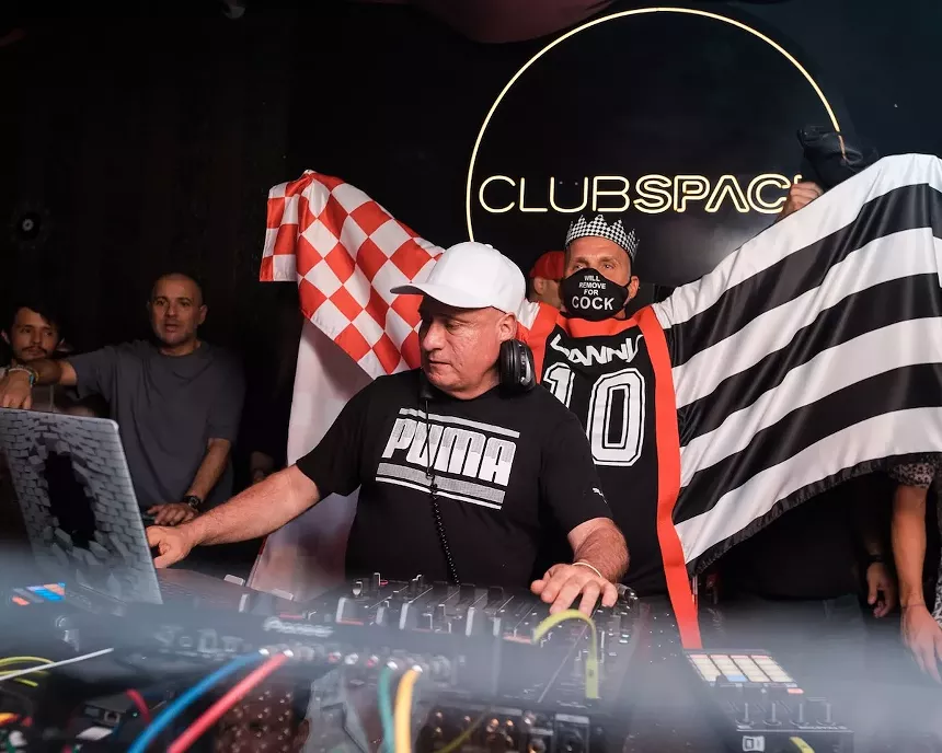 Danny Tengalia spins on the decks with Alan T cheering behind him
