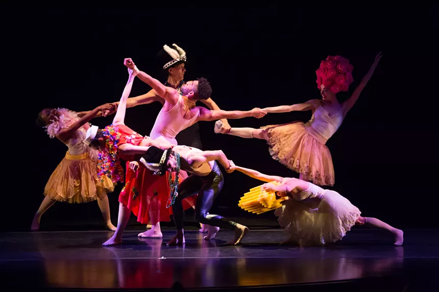 Dancers in costume on stage holding hands