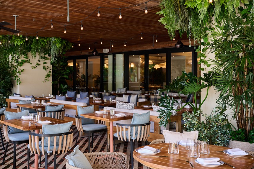 An outdoor dining room with lush greenery