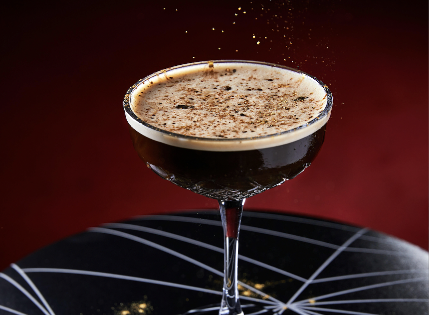 A dark brown cocktail with garnish