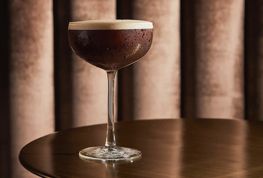 A brown cocktail in a tall cocktail glass