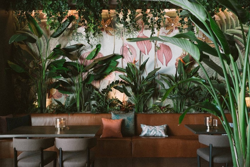Tropical plants and banquettes in a restaurant dining room