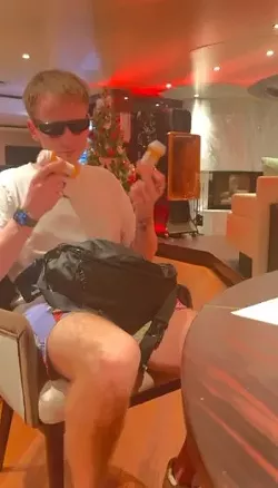 A young gentleman in sunglasses holding up a few pill bottles
