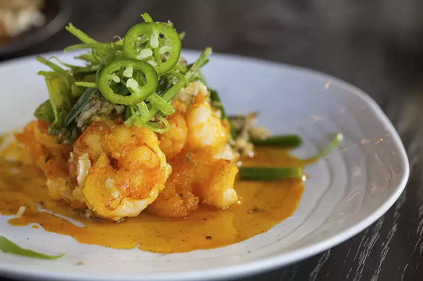 A shrimp dish with green garnish