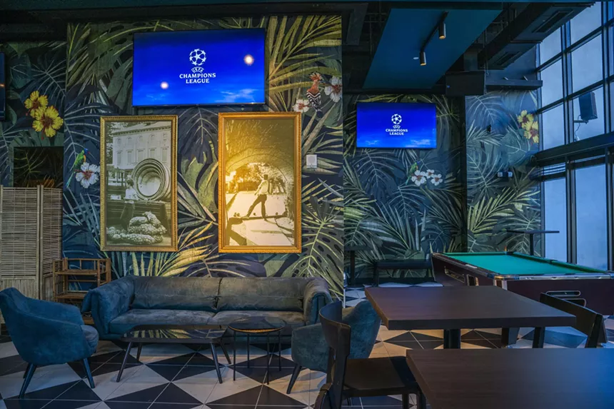 TVs and a pool table at a bar