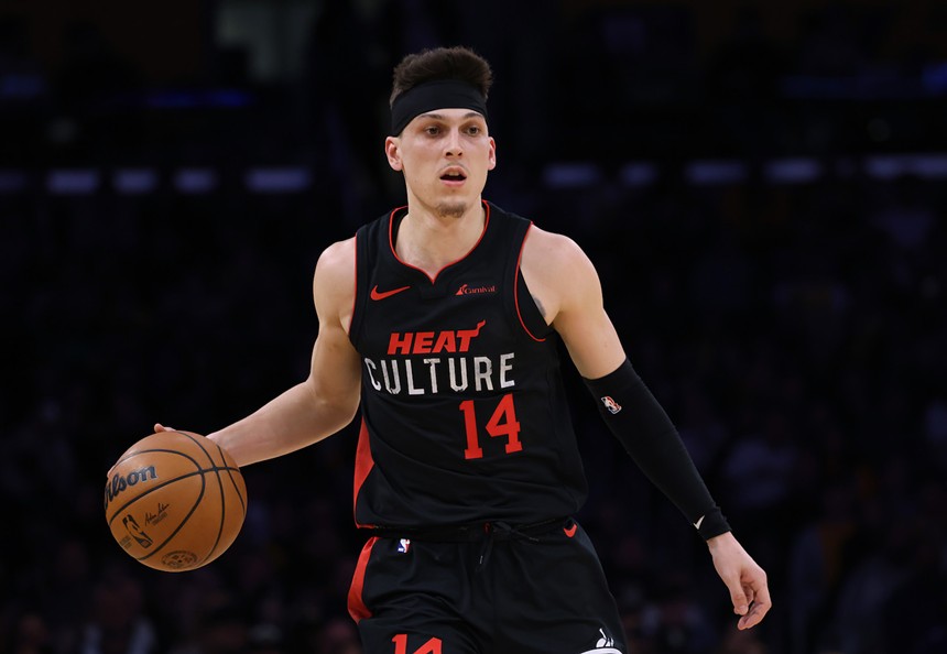 Tyler Herro, clad in a black "Heat Culture" jersey, holding a basketball, and looking fierce