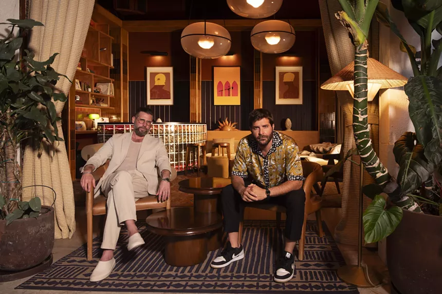 Two men sitting down in chairs