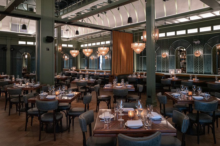 A large dining room with wooden tables and chandeliers