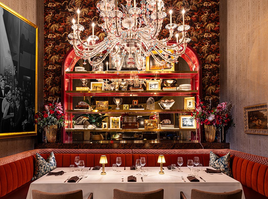 A red dining room with a crystal chandelier