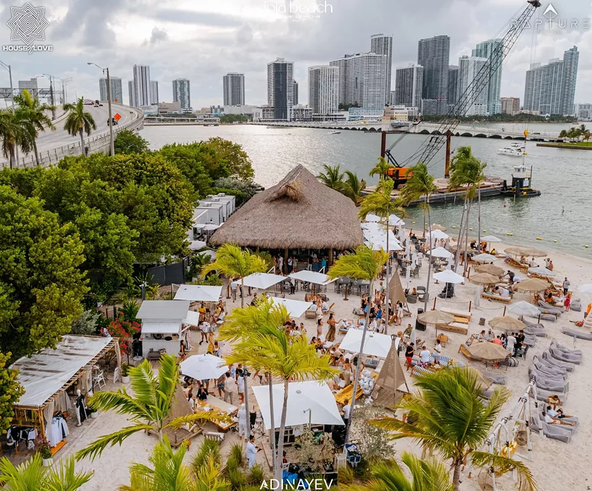 A beach club with tiki hut and cabanas