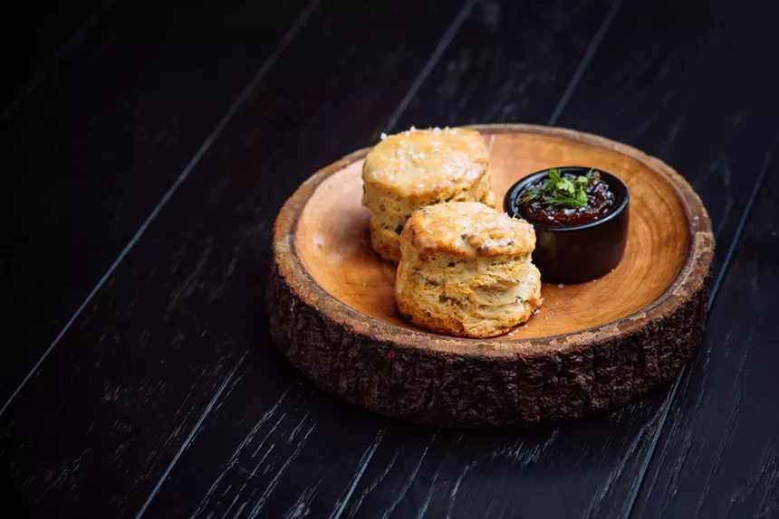 A roll of bread on a black plate