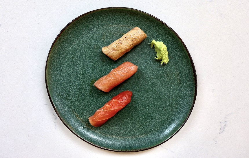 three nigiri on a green plate
