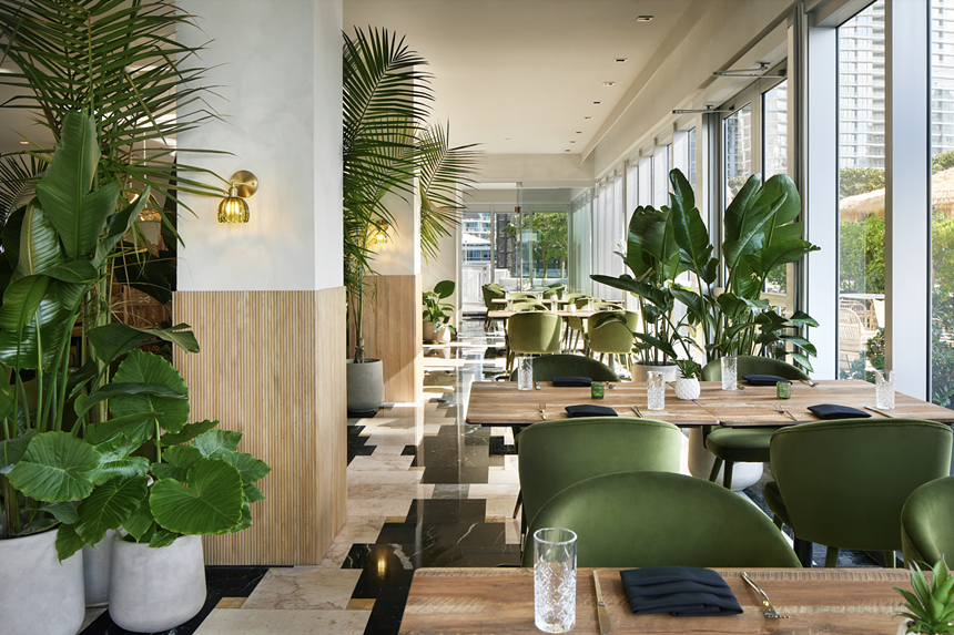 a restaurant with wood seating and greenery