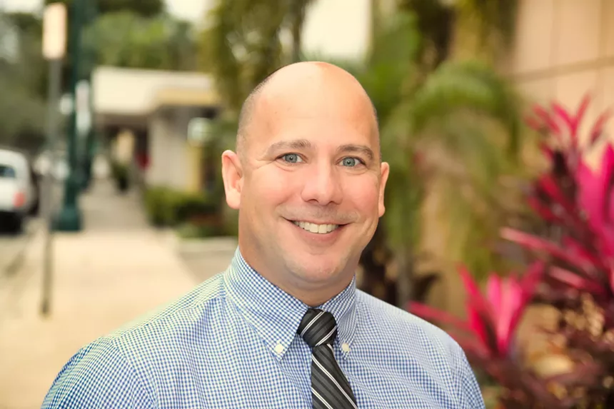 Local news blog publisher smiles wide while wearing a tie and blue dress shirt