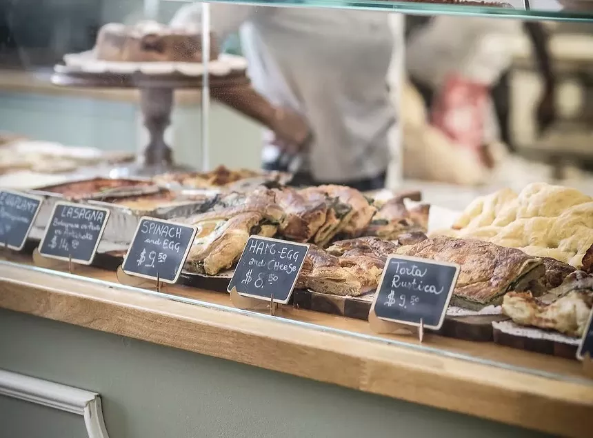 a row of pastries and baked goods behind a glass