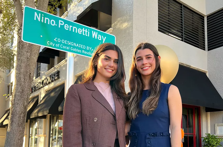 two women posing for a photo outside