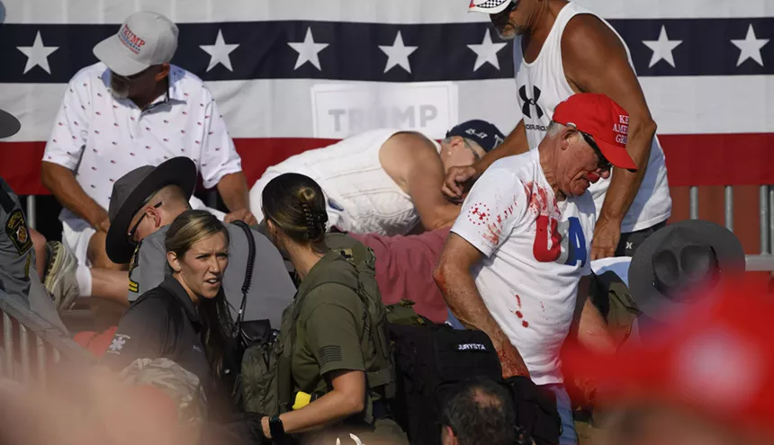 Audience members at a Trump rally in Pennsylvania flee after gunshots break out. One man is spattered with blood.