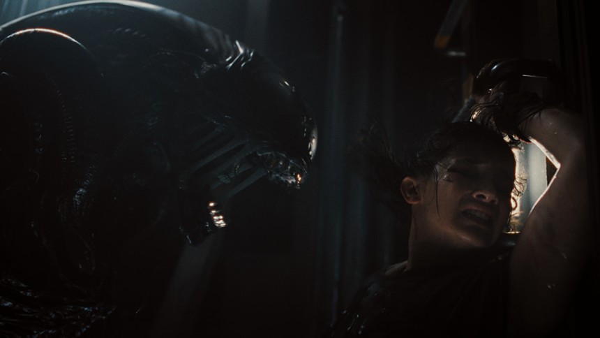 Still of a Xenomorph and Cailee Spaeny in Alien: Romulus