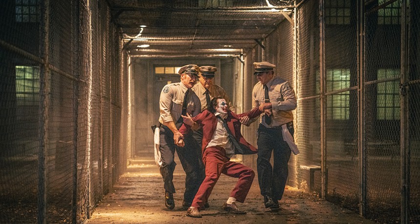 Joaquin Phoenix being dragged by police officers in Joker: Folie à Deux