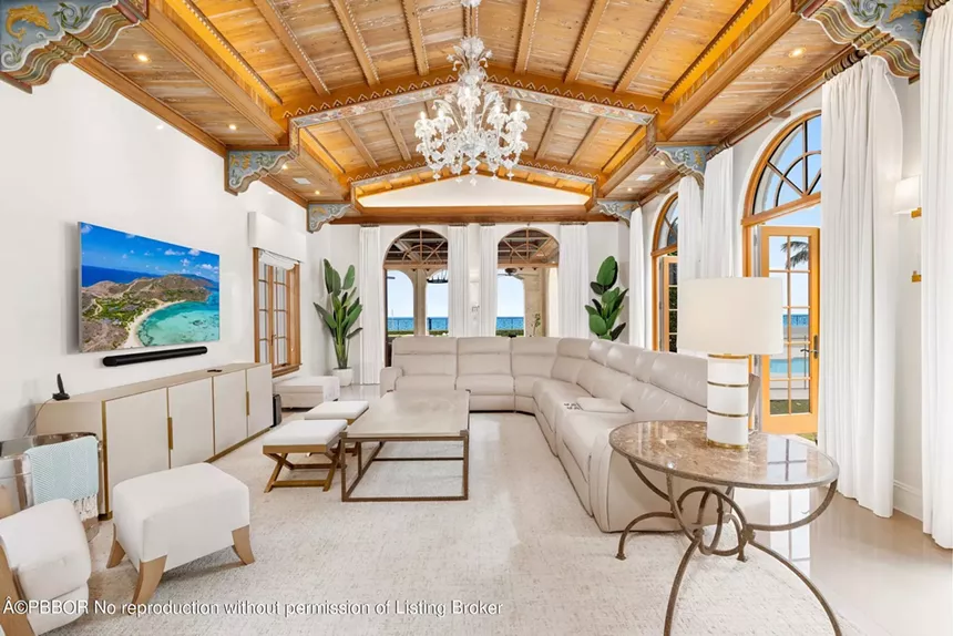 Cozy living room with a vaulted wood ceiling, chandelier, and ocean views