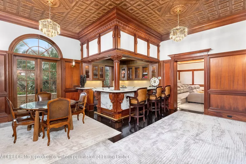 Luxurious wood-paneled bar area with marble counters and seating