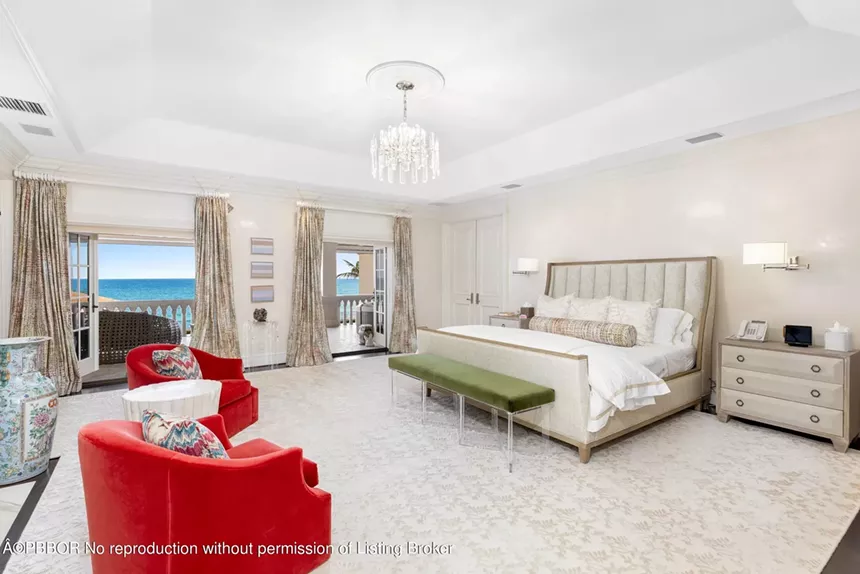 Spacious master bedroom with ocean views, balcony access, and elegant decor