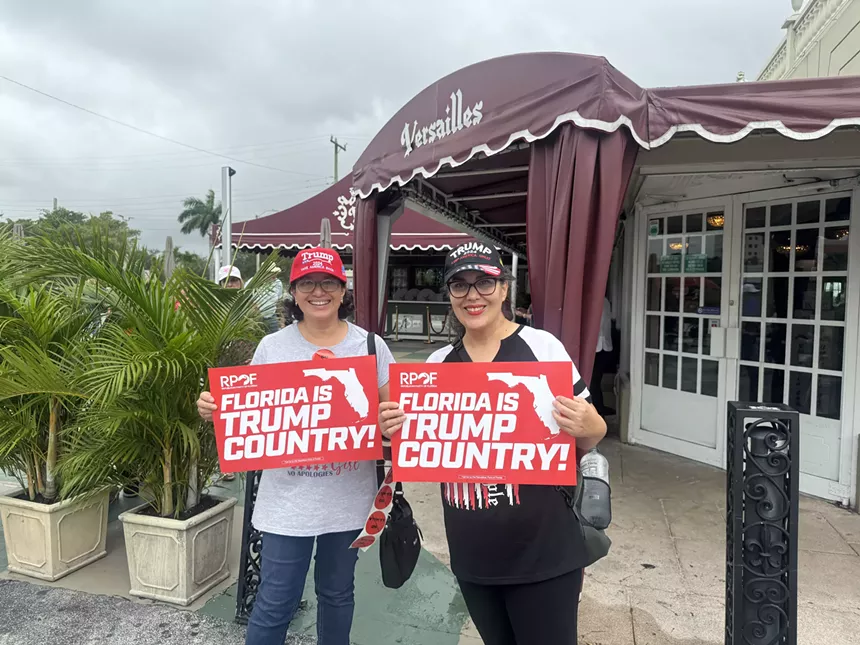 two women hold trump signs