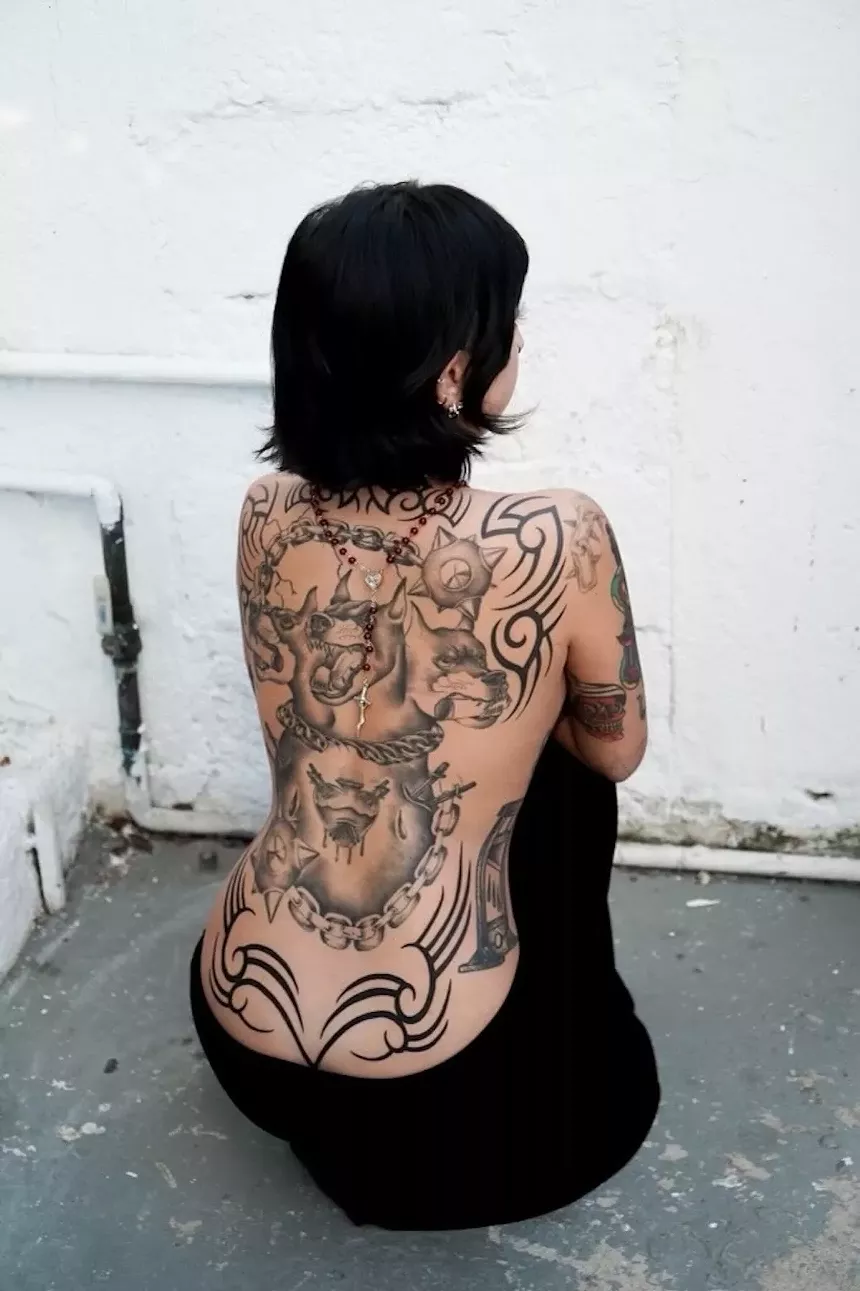 Woman crouching down to show her full-back tattoo