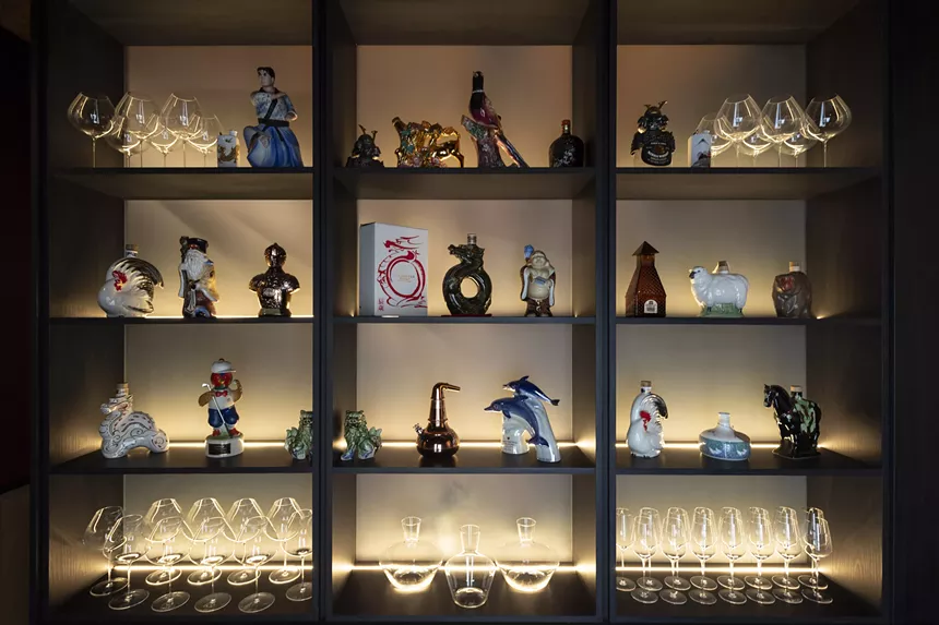 a shelf with glasses and knick knacks