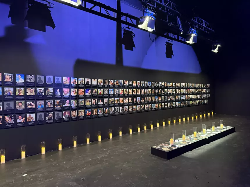 Wall filled with pictures of people who were murdered at the Nova Music Festival.