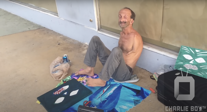 Jonathan Crenshaw, a well-known homeless South Beach street artist with no arms, paints a canvas using his feet.