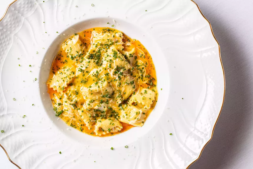 a yellow pasta on a white plate