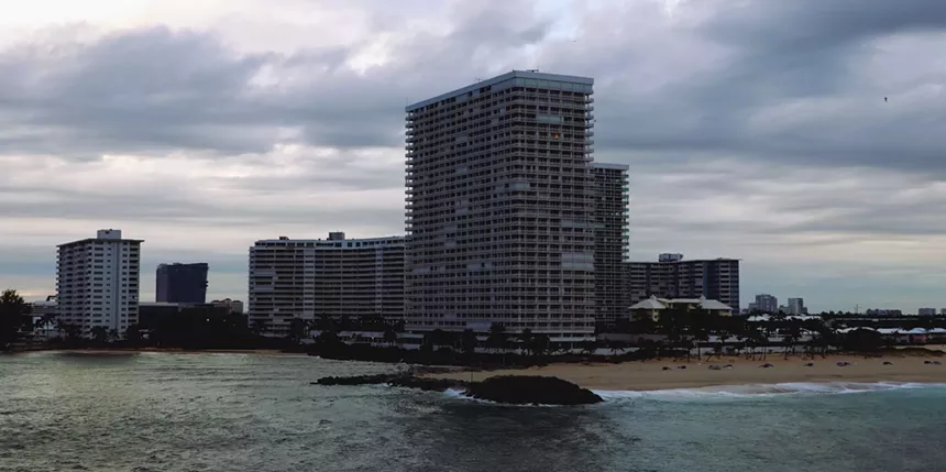 view of the shore from the water with buildings
