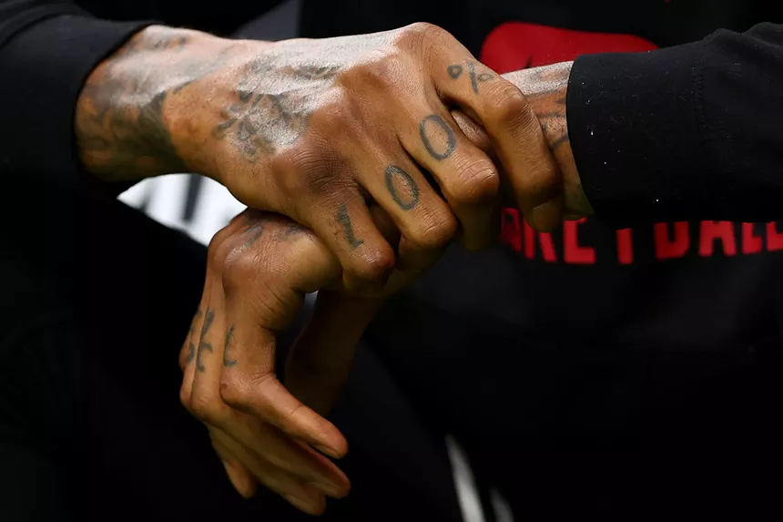 closeup of Miami Heat great Udonis Haslem's hands showing the "100%" that's tattooed across his fingers