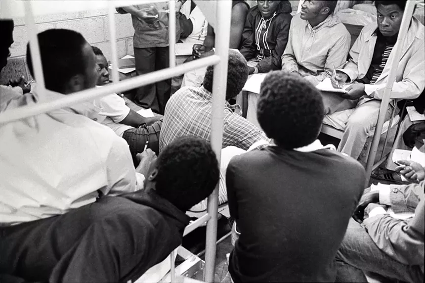 Male detainees sitting on beds inside what is now known as the Krome Detention Center.