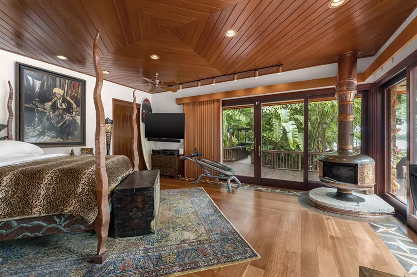 The wood primary bedroom with copper fireplace