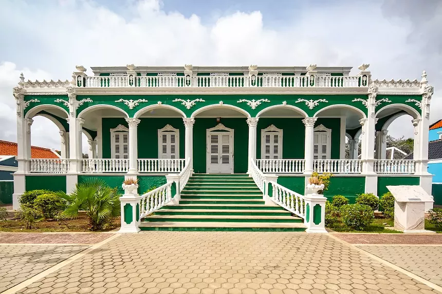 a green European-style residence with white trim